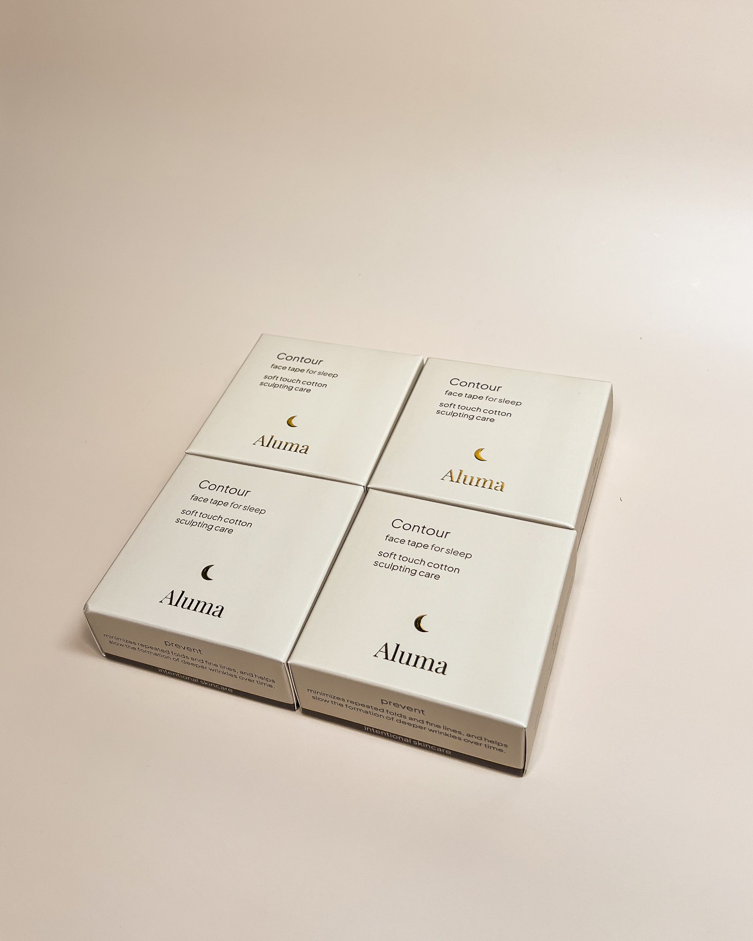 Four Aluma Contour face tape for sleep boxes arranged in a neat grid on a warm beige background.
