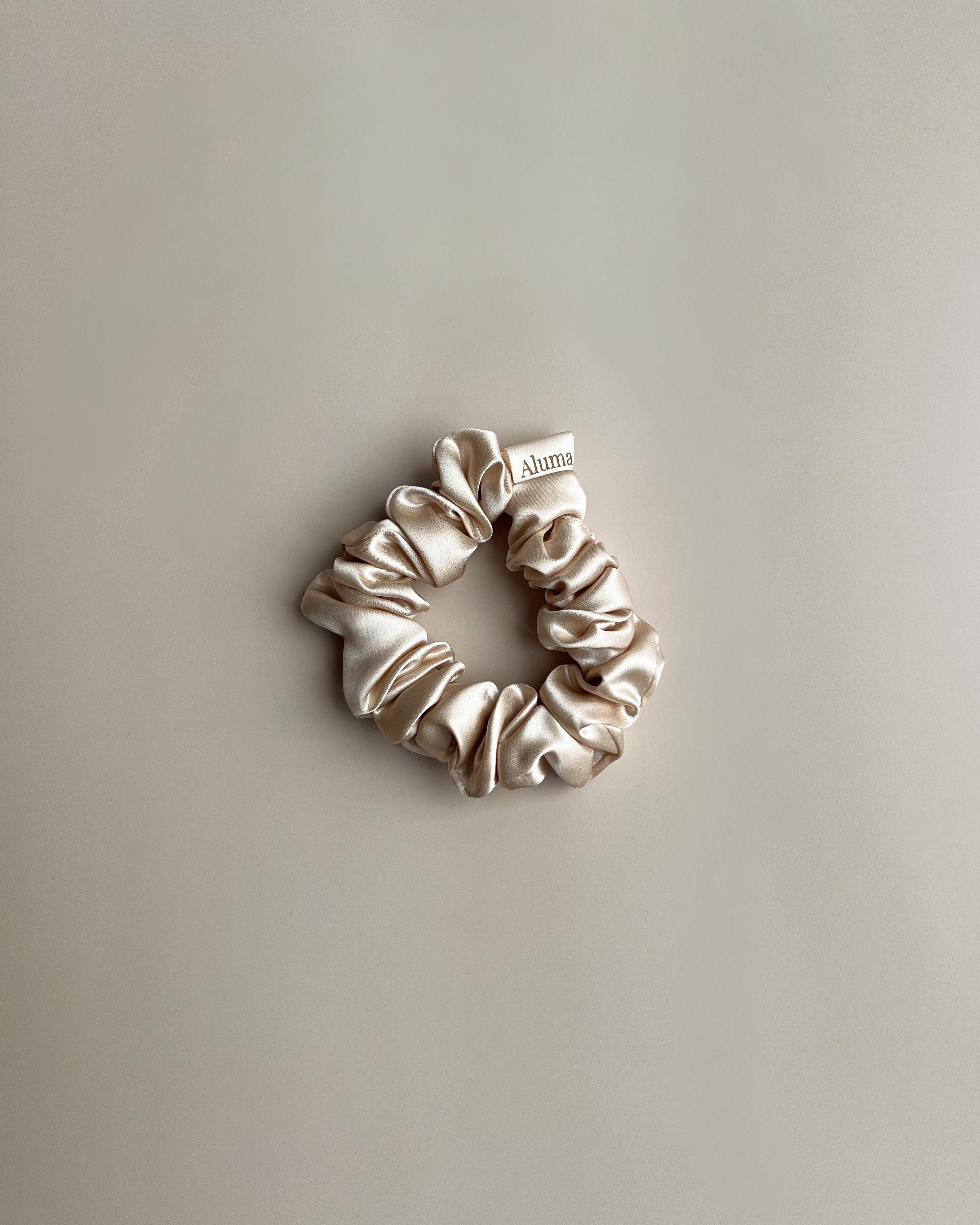 Aluma Bloom silke scrunchie 2,5 cm i Sunbeam Sand champagne beige, økologisk mulberry silke hårelastik med høj glans.