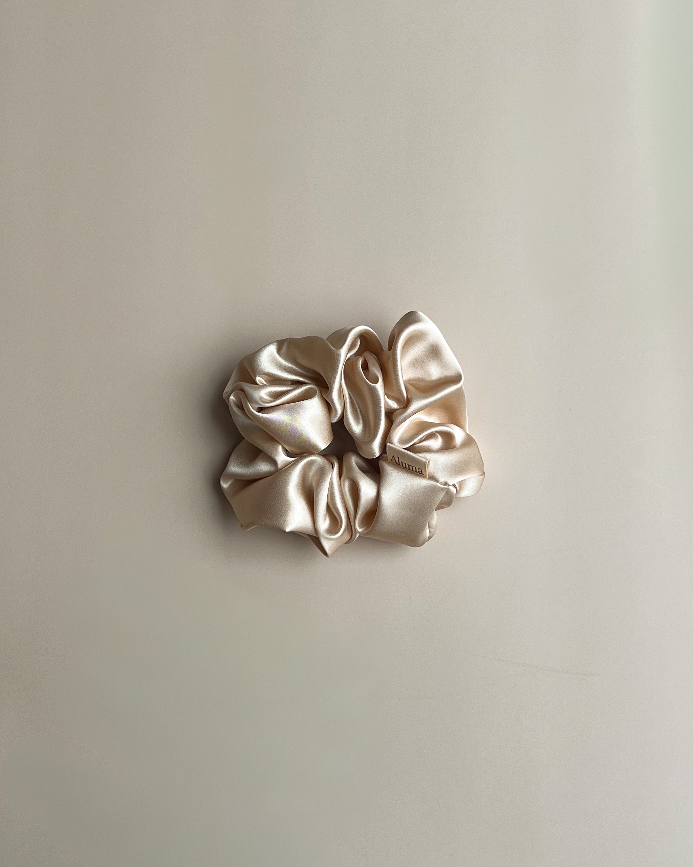 Oversized silke scrunchie 5 cm fra Aluma Bloom i Sunbeam Sand varm sandtone, bæredygtig mulberry silke med blød glans.