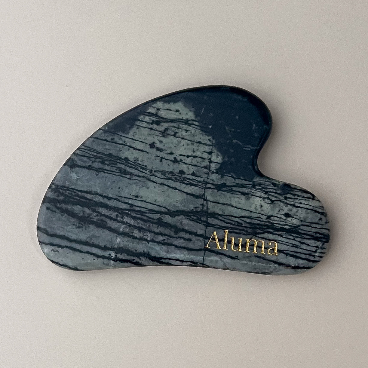 Yin gua sha i picasso-sten fra Aluma til ansigtsmassage og slow aging ritualer.