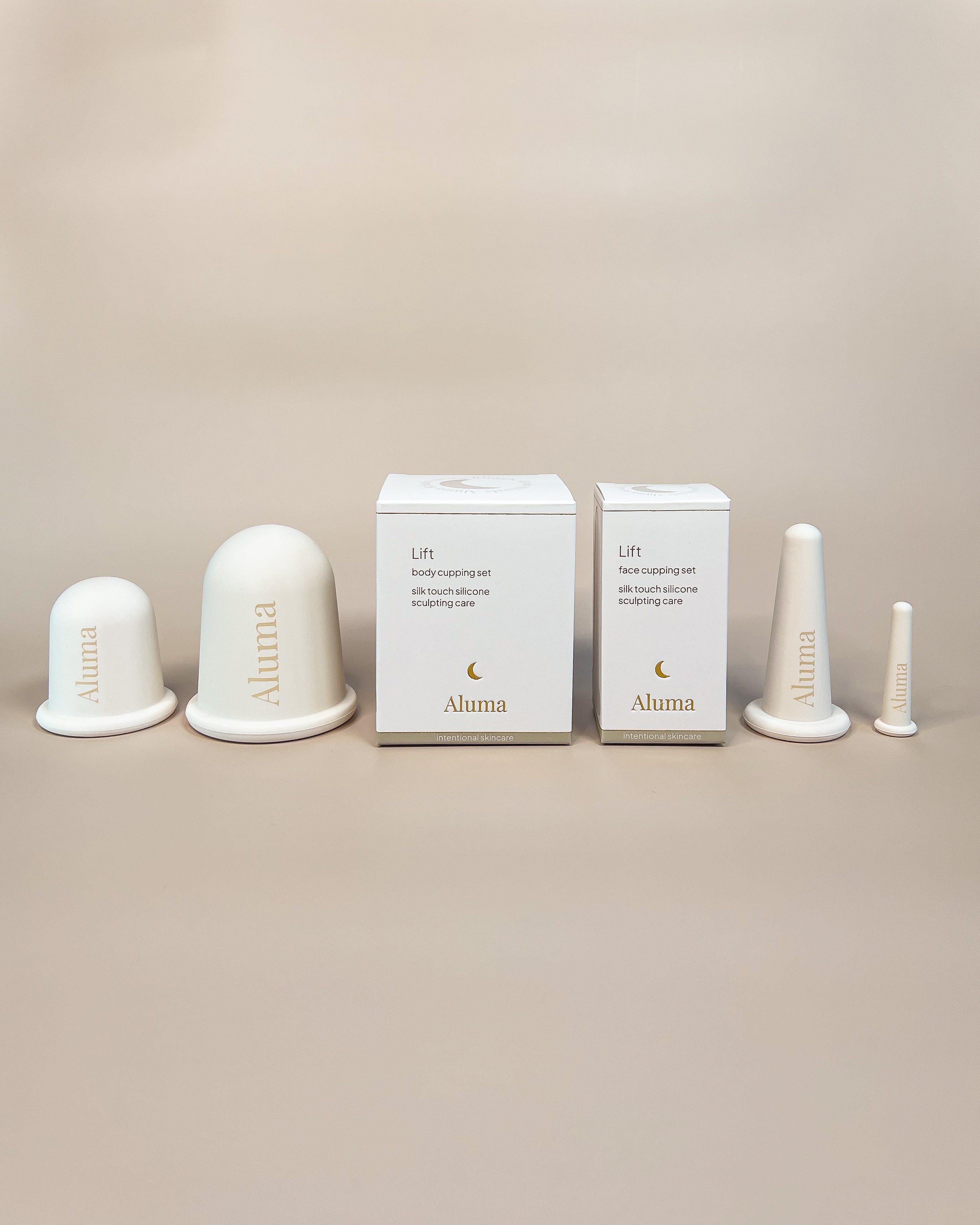 Aluma Lift face cupping sæt med to silikonekopper til ansigtet og hvid emballageæske på beige baggrund