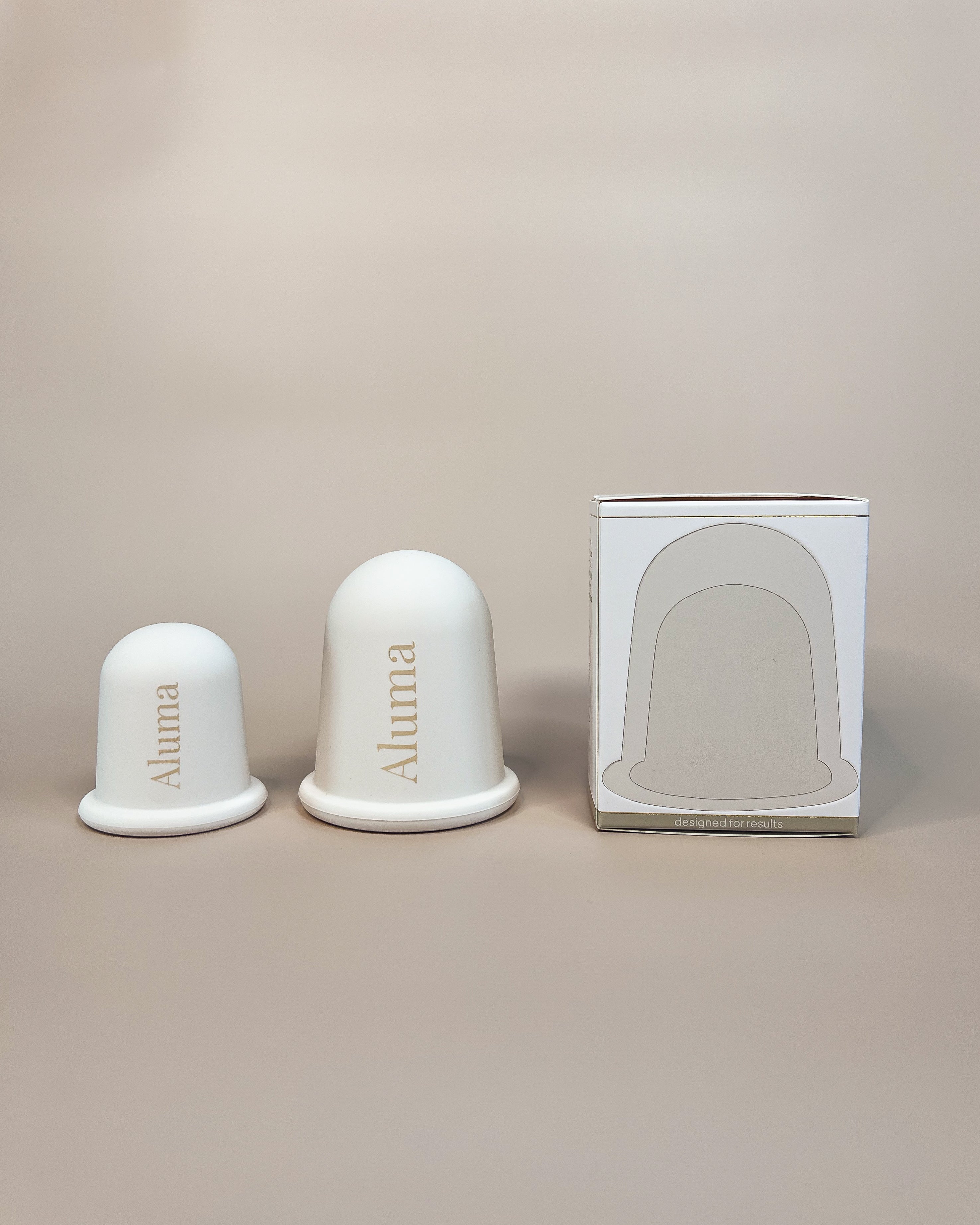 Aluma Lift body cupping sæt med to silikonekopper til krop og illustreret emballageæske, produktbillede på beige baggrund