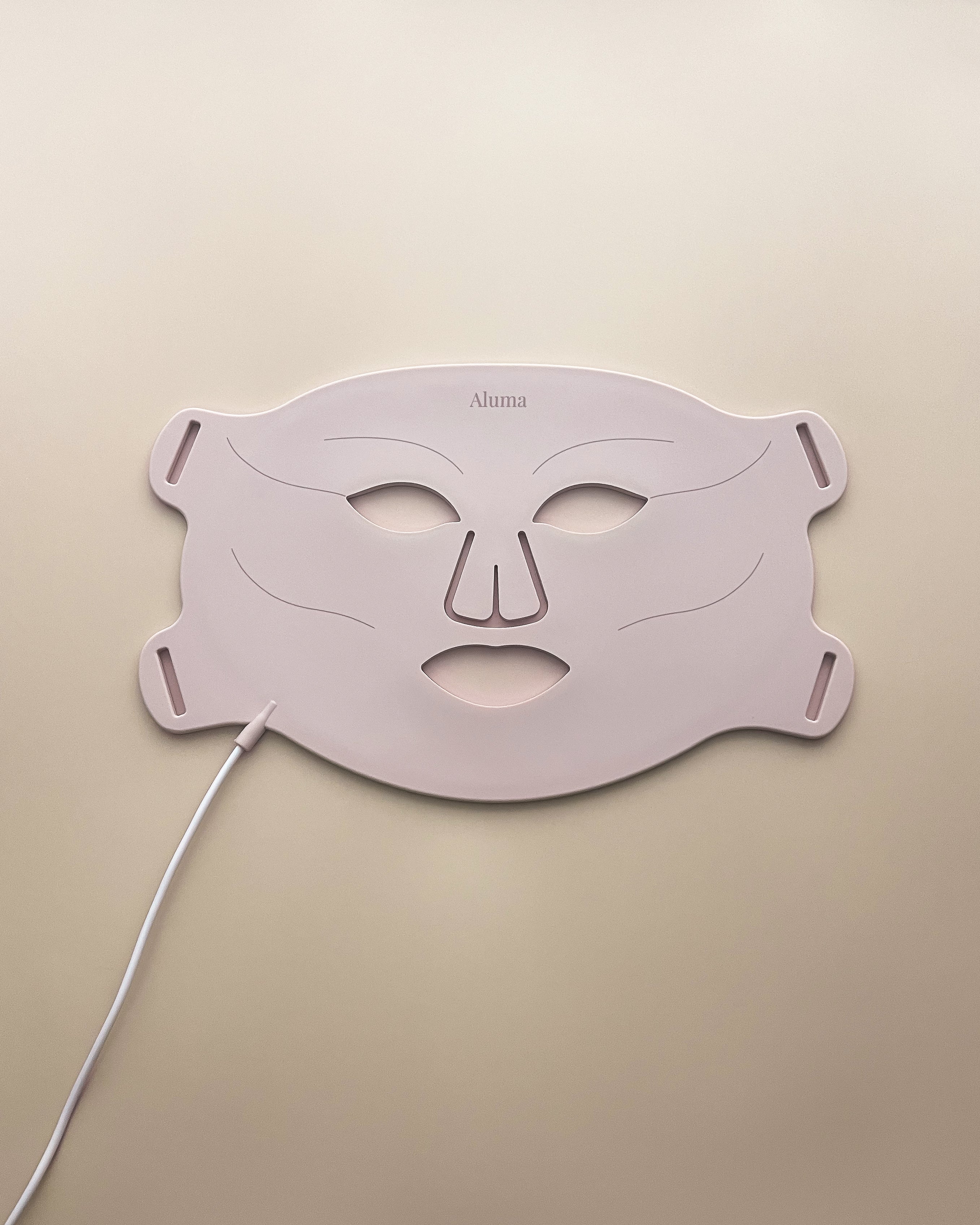 aluma luminous pro led maske lysterapi beige baggrund mod rynker, akne og pigmentforandringer.