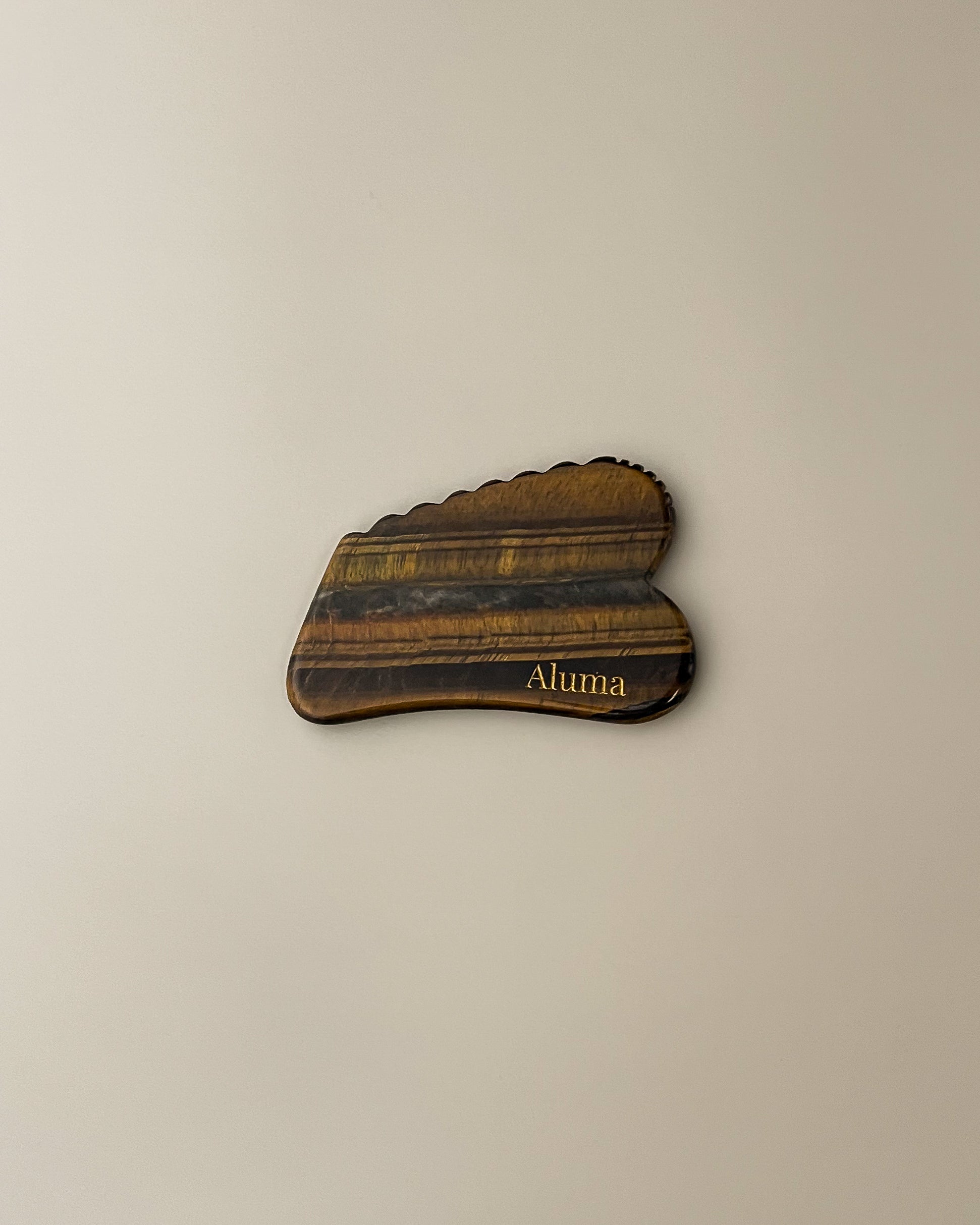 Aluma Ori gua sha i tigerøje sten til opstrammende massage og øget mikrocirkulation.